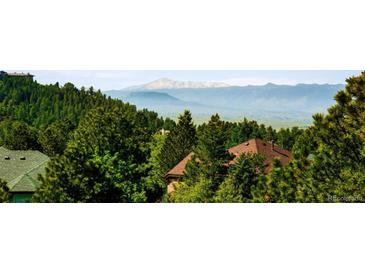Scenic view of mountains and lush trees from this property provides peaceful and picturesque landscapes at 7332 Woodglen Pl, Castle Pines, CO 80108