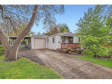 Charming single-story home featuring a detached garage and a cozy front porch with wood trim details at 4285 Newland St, Wheat Ridge, CO 80033