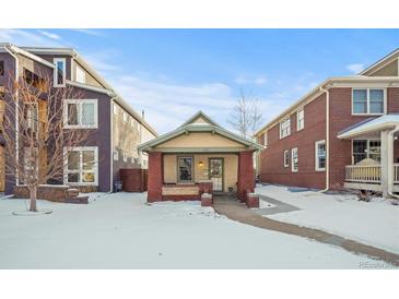 Brick bungalow home exterior, snowy front yard, walkway at 4234 N Raleigh St, Denver, CO 80212