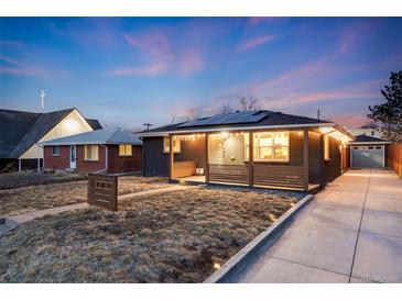 Charming home with solar panels, brick facade, front porch with decorative wood and long driveway at 1742 S Alcott St, Denver, CO 80219