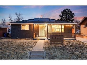 Charming home showcasing a beautifully landscaped front yard and solar panels on roof at 1742 S Alcott St, Denver, CO 80219