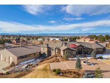 An expansive estate with a circular driveway, fountain, and mountain views at 6302 Charrington Dr, Cherry Hills Village, CO 80111
