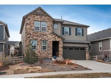 Charming two-story home with a stone facade and well-maintained landscaping at 8010 Blue River Ave, Littleton, CO 80125