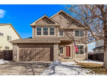 Two-story house with a brown exterior, red door, and attached garage at 672 Pitkin Way, Castle Rock, CO 80104