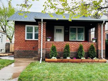 Charming brick home with a cozy front porch, freshly manicured lawn, and beautiful curb appeal at 1939 S Sherman St, Denver, CO 80210