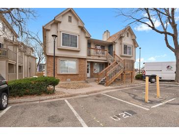 Charming two-story condo featuring a brick facade, wooden stairs, balcony and dedicated parking space at 195 S Sable Blvd # U12, Aurora, CO 80012