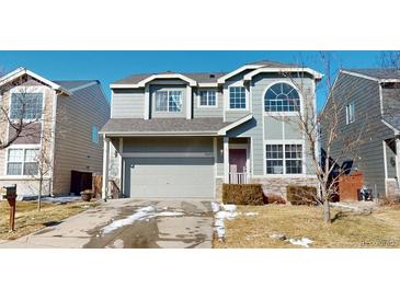 Two-story home with gray siding, attached two-car garage, and manicured front yard at 9649 Lansing Cir, Commerce City, CO 80022