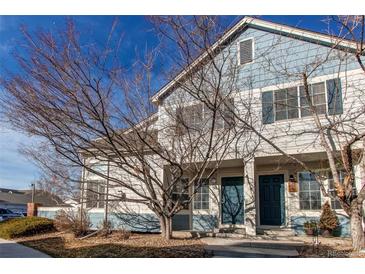 Two-story townhome with blue accents, covered porch, and mature landscaping at 9576 Deerhorn Ct # 50, Parker, CO 80134