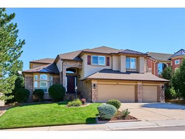 Stunning two-story home featuring a three-car garage and a beautifully landscaped front yard under a clear blue sky at 1328 Double Eagle Ct, Castle Rock, CO 80104