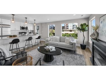Bright, open-concept living room featuring hardwood floors, modern decor, and a breakfast bar at 2140 S Ash St # 101, Denver, CO 80222