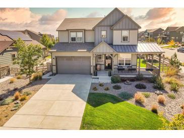 Charming two-story home with a well-maintained lawn and a covered front porch at 8378 Arapahoe Peak St, Littleton, CO 80125