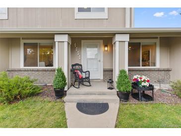 Inviting front porch with a rocking chair and decorative plants at 4650 S Idalia St, Aurora, CO 80015