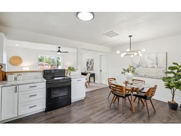 Bright kitchen boasts modern cabinets, an eat-in dining area, and dark hardwood floors at 1330 Oak Pl, Thornton, CO 80229