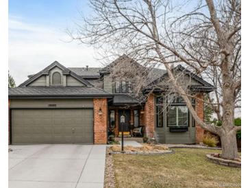 Charming two-story home featuring a brick and siding exterior, manicured landscaping, and an attached two-car garage at 19080 E Low Cir, Aurora, CO 80015