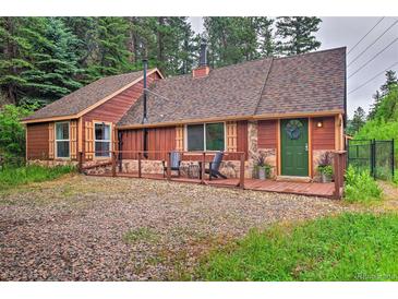 Charming single-Gathering home with a mix of wood and stone exterior, covered entry, and forested surroundings at 7559 S Turkey Creek Rd, Morrison, CO 80465