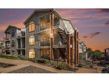 Two-story townhome with brick accents and private balcony at sunset at 1646 S Deframe St # A1, Lakewood, CO 80228