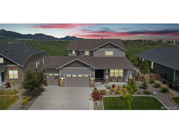 Charming two-story home with mountain views, well-manicured lawn, and welcoming front porch at 8803 Antero Ct, Arvada, CO 80007