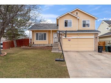 Two-story home featuring a well-maintained front yard and a two-car garage with a basketball hoop at 12119 Forest St, Thornton, CO 80241