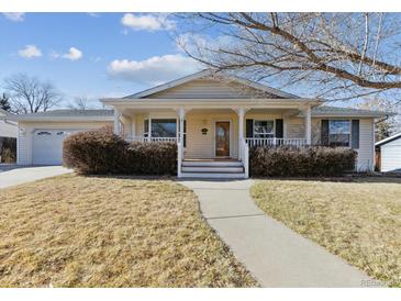 Ranch style home with front porch and landscaped lawn at 7447 Quay St, Arvada, CO 80003