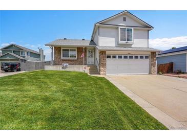 Charming two-story home with a well-manicured lawn and stone accents at 12366 Elm Way, Thornton, CO 80241
