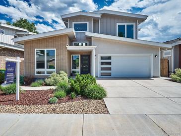 Contemporary two-story home featuring a brick accent, a two-car garage, and professional landscaping at 6096 W Keene Ave, Denver, CO 80235