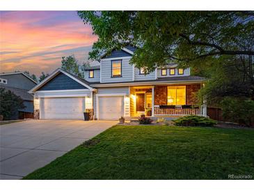 Charming two-story home with a three-car garage, lovely landscaping, and a cozy front porch with stone accents at 531 Americana Rd, Longmont, CO 80504