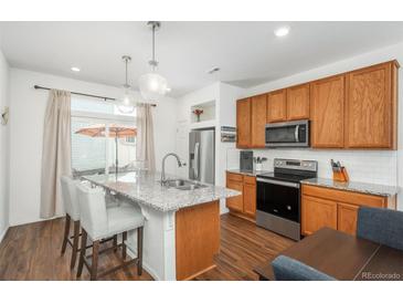 Bright, modern kitchen with granite countertops, stainless steel appliances, and a center island at 4431 N Quatar Ct, Aurora, CO 80019