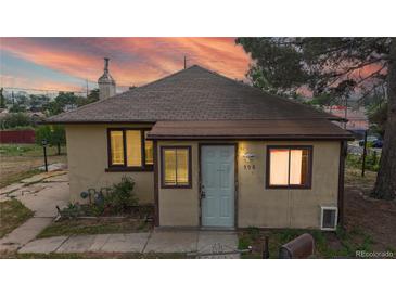 Charming single-story home featuring a welcoming front door and well-lit windows against a colorful sunset backdrop at 598 S Navajo St, Denver, CO 80223