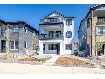 Charming three-story home featuring double balconies, a modern white facade, and professional landscaping at 8509 Orchard City Dr, Littleton, CO 80125