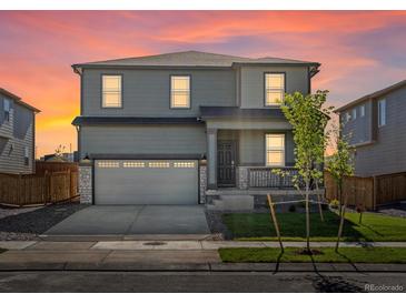 Charming two-story home with a well-manicured lawn, front porch, and two car garage at 8850 Sedalia St, Commerce City, CO 80022