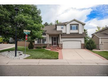Charming two-story home with a well-manicured lawn, mature trees, and a two-car garage at 4501 Whitehall Ln, Highlands Ranch, CO 80126