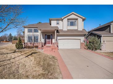 Charming two-story home with a well-maintained lawn and a brick pathway leading to the front door at 4501 Whitehall Ln, Highlands Ranch, CO 80126