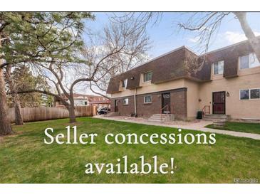 Townhouse with brick facade and lush green lawn at 7755 E Quincy Ave # T80, Denver, CO 80237