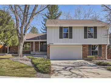 Charming two-story home with brick and white siding, complemented by a two-car garage and professionally landscaped yard at 7998 S Wabash Ct, Centennial, CO 80112