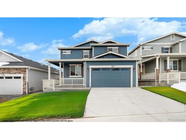 Charming blue two-story home with a covered front porch, a manicured lawn, and a two-car garage at 2165 Peralta Loop, Castle Rock, CO 80104
