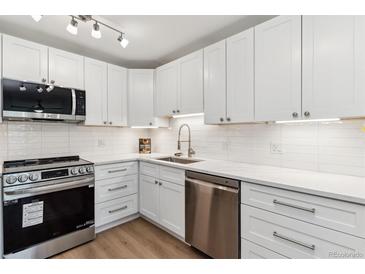 Modern kitchen with white cabinets, stainless steel appliances, and quartz countertops at 775 S Alton Way # 2C, Denver, CO 80247