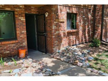 Inviting front entrance with red brick facade, screen door, and rock accents around the exterior of the home at 2261 S Buckley Rd # 102, Aurora, CO 80013