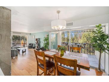 Open dining and living area with natural light and sliding glass doors to a balcony with great tree views at 1223 Race St # 402, Denver, CO 80206