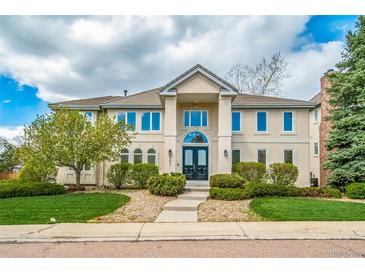 Stunning two-story home featuring a manicured lawn, mature trees, and a grand entrance with double doors at 5191 S Hannibal Way, Centennial, CO 80015