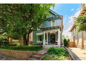 Charming two-story home with a manicured front yard and a beautiful mature tree at 1429 Josephine St, Denver, CO 80206