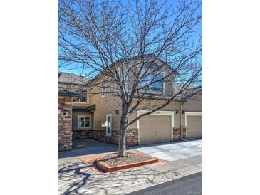 Inviting home exterior with attached garage, stone accents, manicured lawn, and charming curb appeal at 11257 W Radcliffe Dr, Littleton, CO 80127