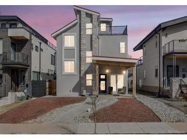 Contemporary two-story home with stone accents, a balcony, a porch with a swing, and modern curb appeal at 3948 Wyandot St, Denver, CO 80211