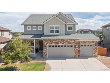 Charming two-story home with brick accents, gray siding, and a well-maintained lawn at 1315 Sidewinder Cir, Castle Rock, CO 80108