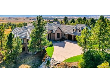 Beautiful home featuring lush landscaping, a paved driveway, and a tile roof in an upscale neighborhood at 770 International Isle Dr, Castle Rock, CO 80108