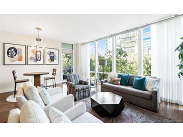 Bright living room featuring floor to ceiling windows, modern decor, and hardwood floors at 1401 Delgany St # 202, Denver, CO 80202