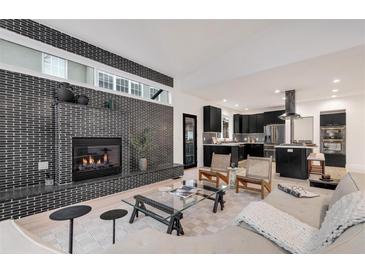 Open-concept living room with brick fireplace, modern decor, and seamless flow to the kitchen at 520 Columbine St, Denver, CO 80206