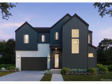 Striking new construction home with modern design, dark siding, stone accents, and lush landscaping at 11324 Alla Breve Cir, Lone Tree, CO 80134