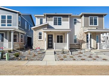 Charming two-story townhome with stone accents and a well-maintained landscaped front yard at 1264 Penner Dr, Erie, CO 80026