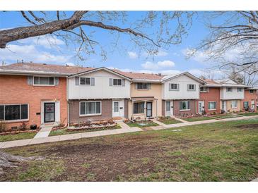 A row of brick and painted townhomes with small front yards and walkways on a partly cloudy day at 12661 W Alameda Dr, Lakewood, CO 80228