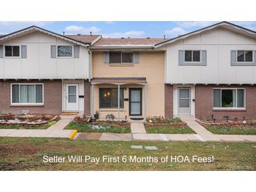 Charming townhome featuring a brick facade and well-maintained front yard at 12661 W Alameda Dr, Lakewood, CO 80228
